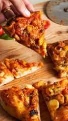 close-up of hand holding pizza slice of Traditional Italian pizza. Traditional food from Palermo, Sicily, Italy. Ingredients Tomato sauce, anchovy, onion, cheese, oregano, oil.