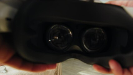 Wearing virtual reality glasses POV, playing video games, gamer using new generation gaming headset for entertainment at home, future technology concept.