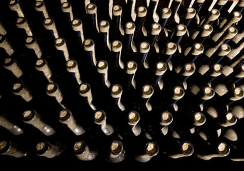 Wine cellar low light interior shot. Wine glass bottle necks with corks backgrounds with a collection of wine bottles. Money investing and winemaking or consumption concept image.