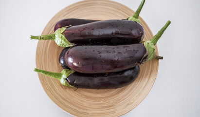 Aubergines on wooden plate - eggplants