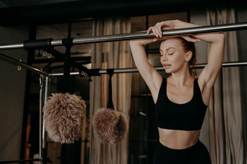 Beautiful redhead fitness woman relaxing on pilates cadillac reformer