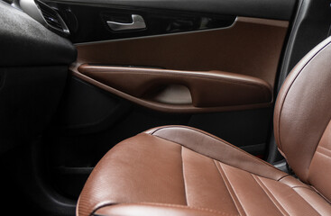 Car brown leather interior. Part of brown perforated leather car seat details with white stitching. Interior of prestige car. Comfortable perforated leather seats. Perforated leather.