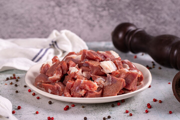 Lamb cubed meat. Chopped red meat in a plate on a stone floor. Butcher products. close up