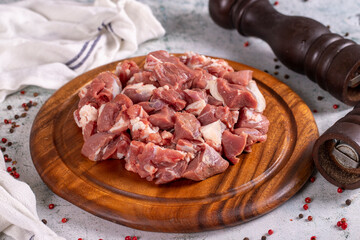 Lamb cubed meat. Chopped red meat in a wooden serving dish on a stone background. Butcher products. close up