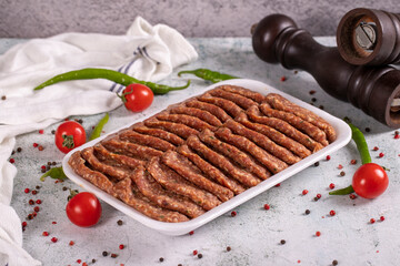 Packaged uncooked spicy grilled meatballs. Meatballs on stone background. close up