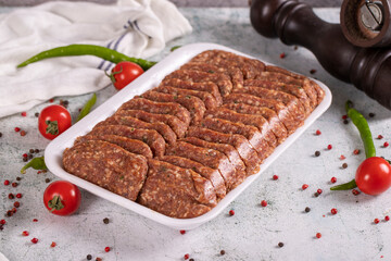 Packaged uncooked spicy grilled meatballs. Meatballs on stone background. close up