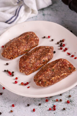 Uncooked spicy grilled meatballs. Meatballs in a plate on a stone background. close up