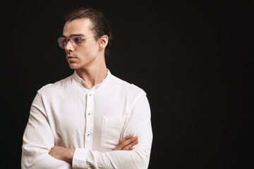 Young handsome man in shirt and glasses with folded arms
