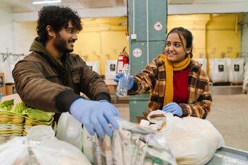 Indian man and woman sorting waste at garbage recycling station