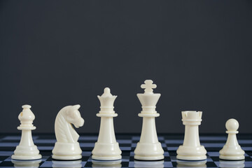 All suits white chess pieces on chess board.