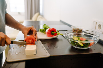 Obraz na płótnie Canvas Male hands cutting vegetables for greek salad close up
