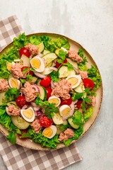 Tuna salad, vegetable salad with quail eggs, lettuce, red onion and cucumbers, on a light gray table, keto food, lifestyle, healthy eating, selective focus, top view, no people,