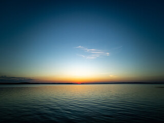 Atmospheric phenomenon - noctilucent clouds. Sunset over the lake, landscape.