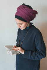 Young jewish woman with covered head prays with siddur (jewish prayer book) in her hands (64)