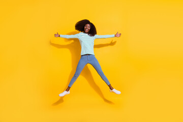Fototapeta na wymiar Full body photo of overjoyed satisfied person jumping raise hands make star figure isolated on yellow color background