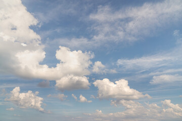 Beautiful well balanced sky replacement background with layers of fluffy white cumulus clouds on a blue sky background.