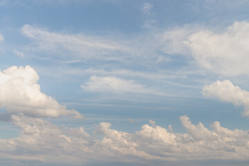 Beautiful well balanced sky replacement background with layers of fluffy white cumulus clouds on a blue sky background.