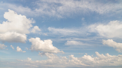 Beautiful panorama or wide angle sky replacement background with layers of fluffy white cumulus clouds balanced well on a blue sky background.