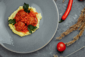 Meatballs in tomato sauce with mashed potato on the white plate, top view, view from above