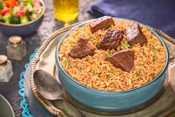 Arabic Cuisine: Orzo stew topped with meat chunks and served with green salad.