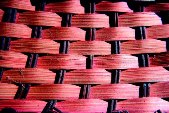 Cesta de mimbre hecha a mano con tejido color rojo para guardar pan, forma olas horizontales con v&agrave;stagos negros verticales, presenta un original dise&ntilde;o abstracto para fondos de textura