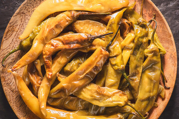 Arabic cuisine, Fried green peppers on wooden plate. Top view with close up.
