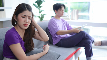 young asian woman sitting on the sofa with anger annoyed boyfriend