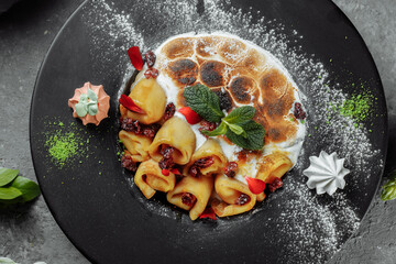 Pancakes with cheese in orange sauce served with caramelized nuts and almonds. Appetizing dish. Culinary photography, a proposal to serve a meal