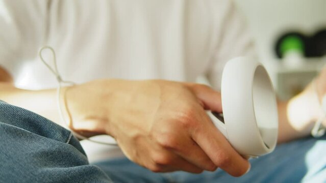 Man holding controllers from virtual reality glasses, playing video games, guy gamer wearing new generation gaming headset for entertainment at home, future technology concept.