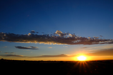 Sun Setting Sunset or Rise Sunrise with Sunstar Rays of Light with Clouds in Sky