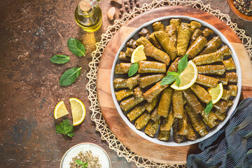 Fototapeta na wymiar Arabic Cuisine; Traditional delicious stuffed vine leaves. Served with yogurt salad and fresh lemon. Top view with close up.
