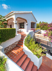 Fototapeta na wymiar Exterior panorama of the entrance of a relaxing holiday vintage villa with a mediterranean garden