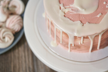 beautiful festive pink birthday cake with smudges of white chocolate around the edges on a stand top view