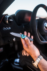 Showing a open Damascus blade pocket knife in front of a steering wheel