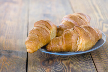 a plate full of croissants on a wooden table
