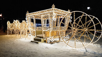 an image of a horse carriage and a carriage made of Christmas lights. new Year's decoration in the...