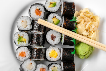 Sushi dish of traditional Japanese cuisine on a white plate, top view