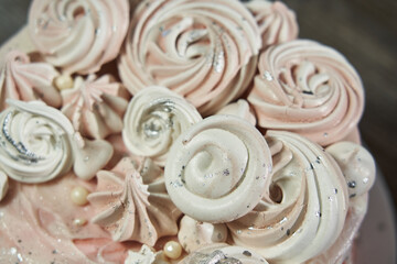 top view of beautiful pink marshmallows in different shapes that decorate a beautiful festive pink birthday cake