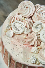 top view of beautiful pink marshmallows in different shapes that decorate a beautiful festive pink birthday cake. partial view