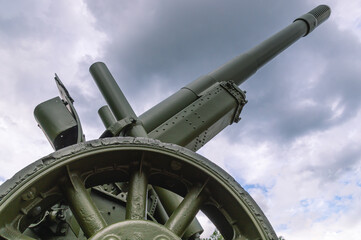 The barrel of a large-caliber howitzer with a muzzle brake. A weapon that shoots at a large trajectory. Cannon-howitzer for long-range shooting.