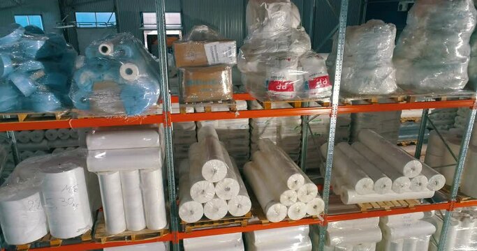 Warehouse at the nonwovens factory. Flight to the warehouse of non-woven fabrics. Large modern warehouse with synthetic winterizer rolls