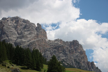 Rock formation with trees in foreground and a cloudy sky