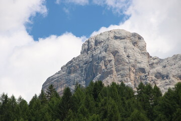 Rock formation with trees in foreground and a cloudy sky