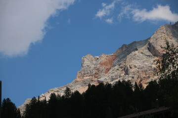 Rock formation with trees in foreground and a cloudy sky