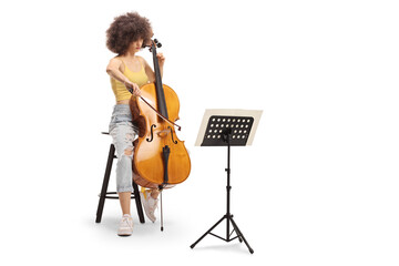 Young female sitting on a chair and playing a contrabass with a music sheet a stand