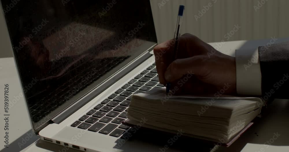Poster the worker's hand uses a pen in writing text on paper. operational recording during a call. the lapt