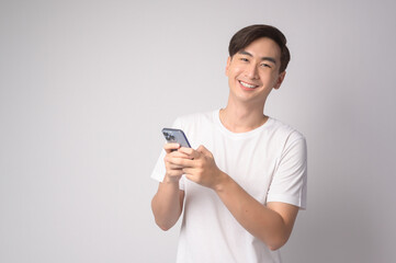 Young asian man using smartphone over white background, technology concept. ..