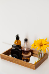 Obraz na płótnie Canvas Perfume, wildflower vase, lotion and liquid soap on mirror tray. Aesthetic minimalist bathroom composition.