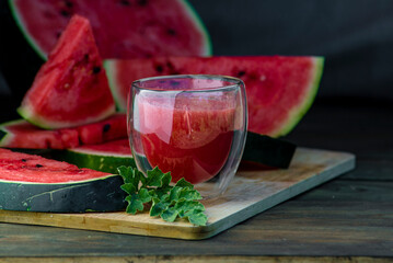 Delicious watermelon  outdoors wooden  table, GREEN  natural background sunny day, Heap,  Fresh ripe red, leaf, summer sunny garden juice drink organic sweet fruit, vegan food Tasty sliced board plate