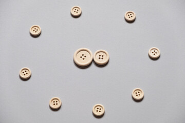 wooden buttons on a gray background. Two buttons in the center. Circle of buttons. The symbol of the family in society. Aggression and protection of the family.